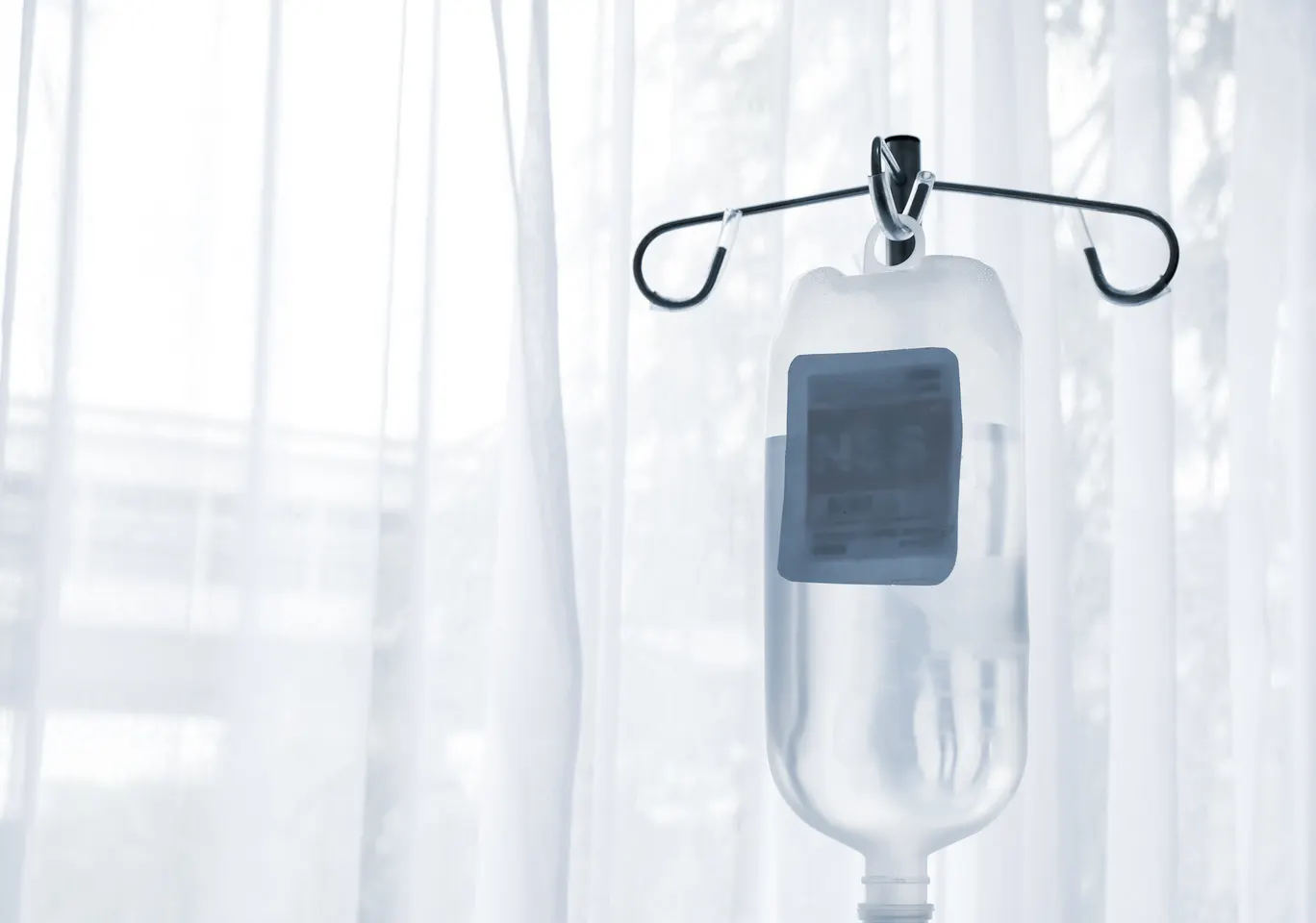 Kroplówki witaminowe Zielona Góra: butelka płynu infuzyjnego zawieszona przy oknie