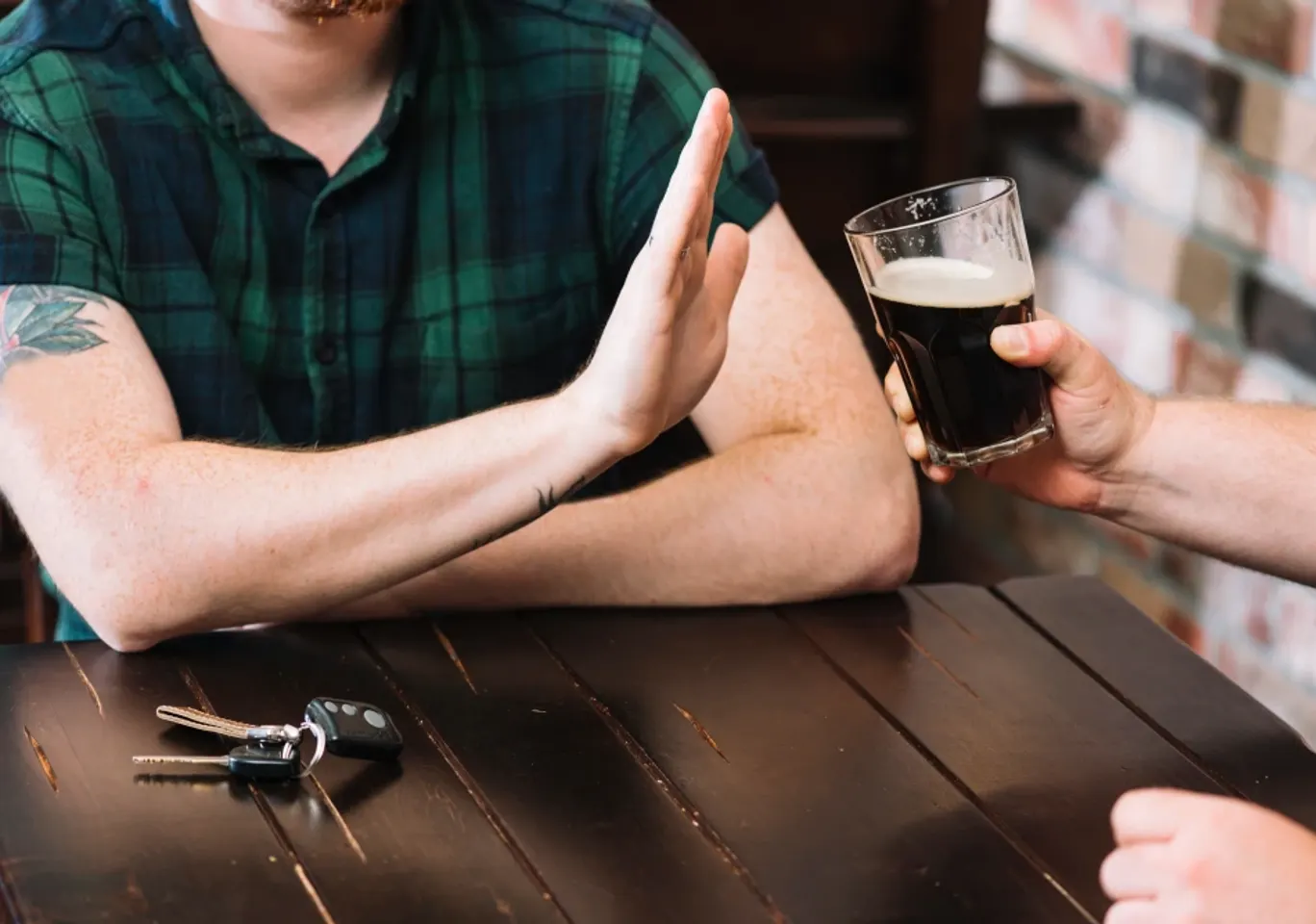 Wszywka alkoholowa Esperal / Disulfiram Zielona Góra: dłoń odmawiająca kufla piwa przy stole